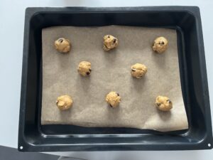 unbaked dough of chocolate walnut cookies on a lined sheet tray