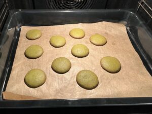 10 baked matcha cookies with brown edge on a baking tray