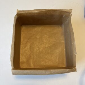 square baking pan lined neatly with parchment paper